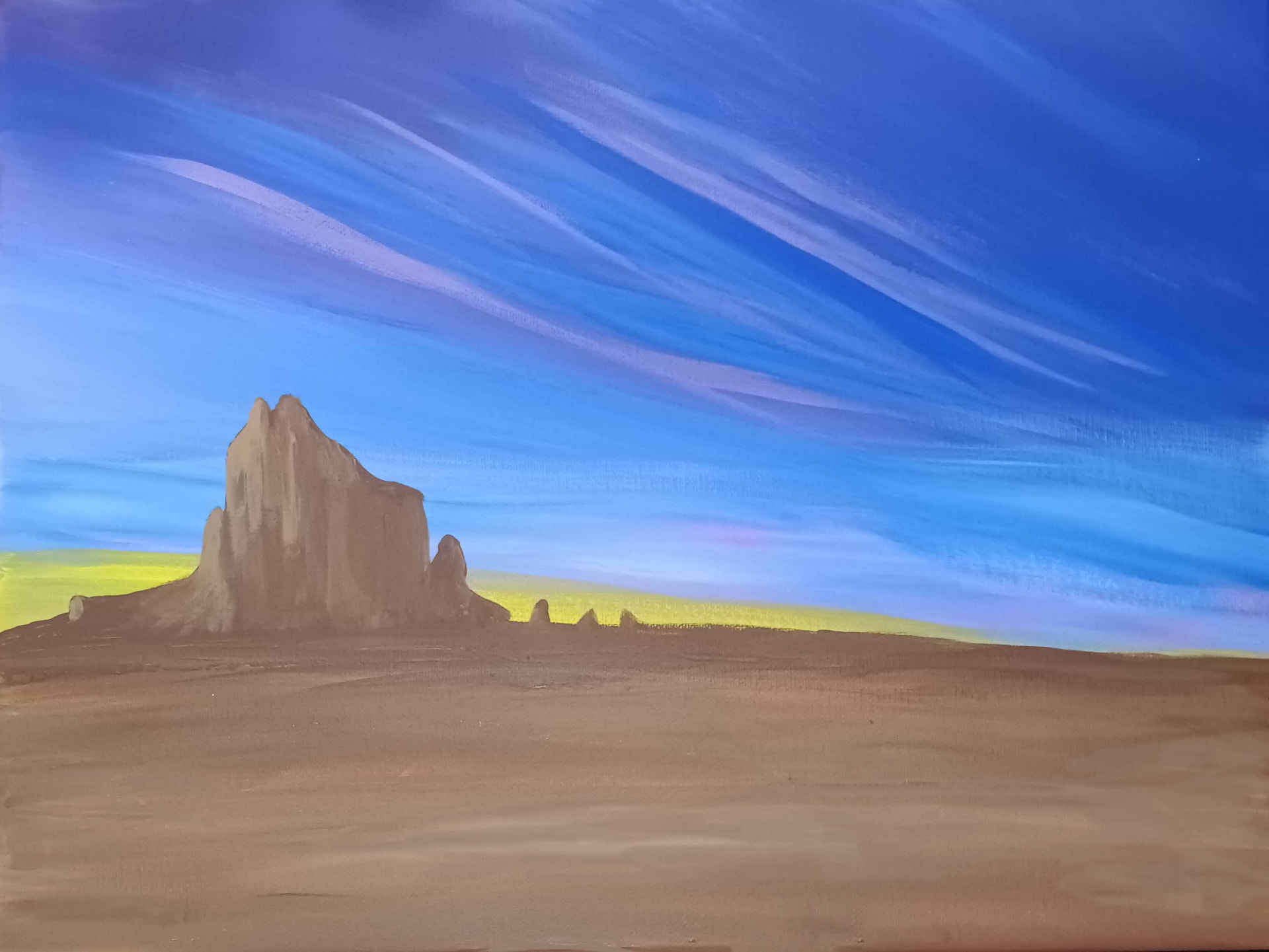 Ship Rock — a sandstone butte rising over the desert floor beneath sweeping streaks of blue sky